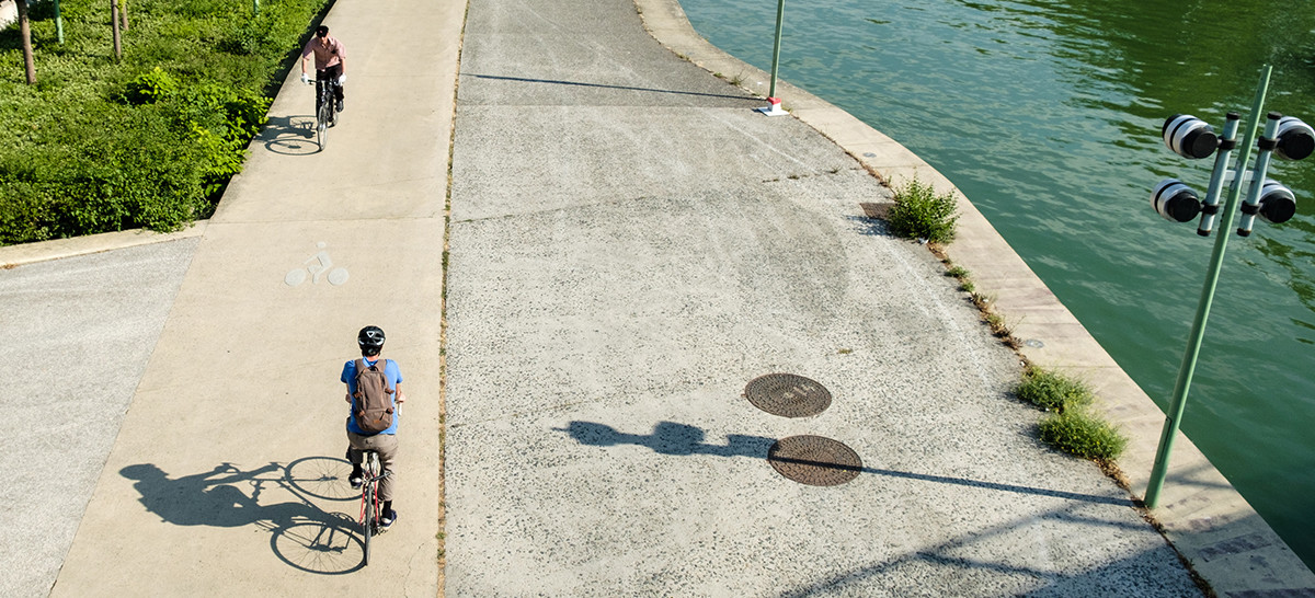 gens se déplaçant à vélo au bord d'un canal 