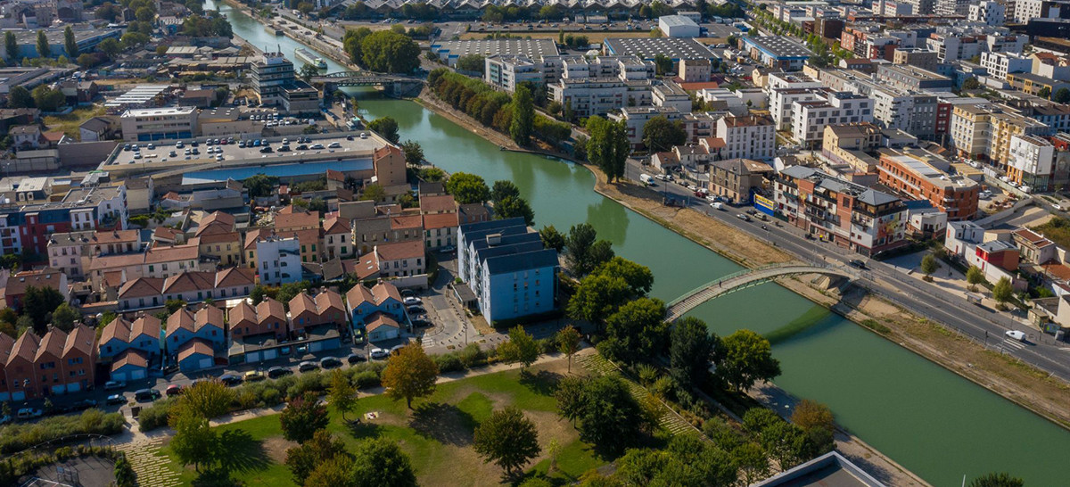 Photo aérienne montrant des immeubles, des maison, un parc, une rivière et des ponts. 